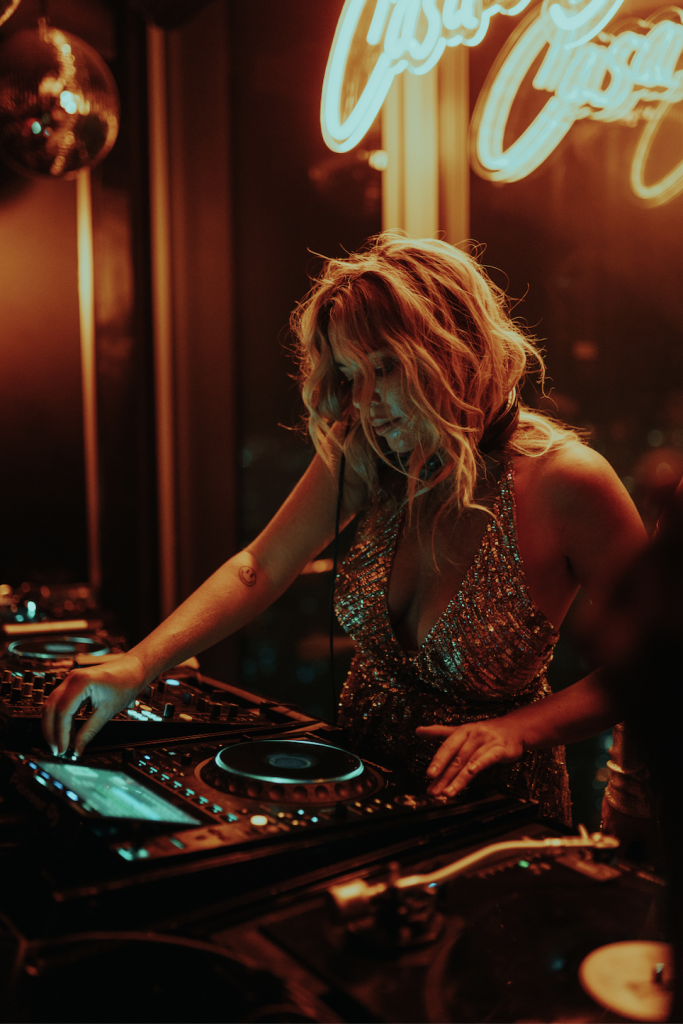 Carly Foxx with glittery dress on the decks playing records