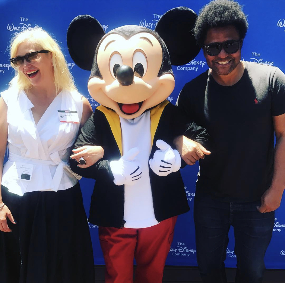 Founder Nichola linked arms with Mickey Mouse in middle and Dom on right