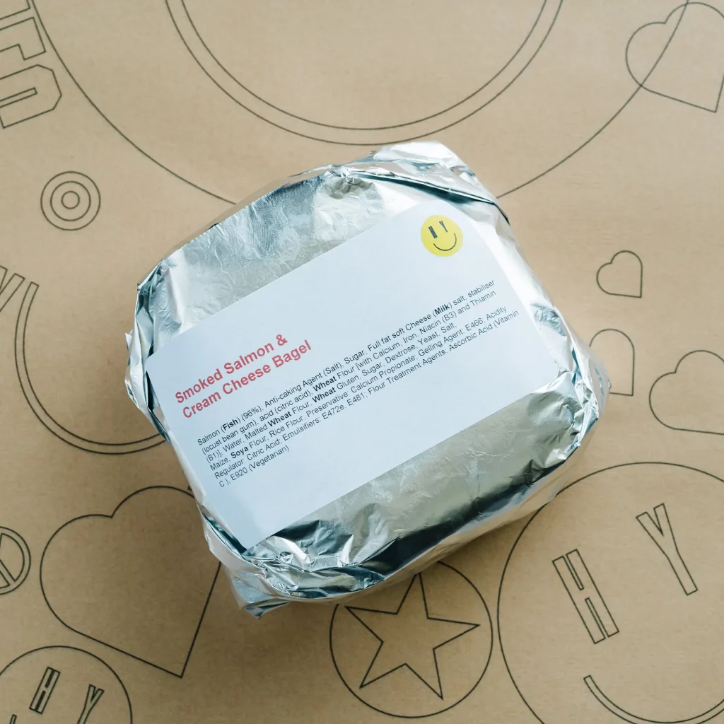 A photograph of a Yummies bagel, wrapped in foil.