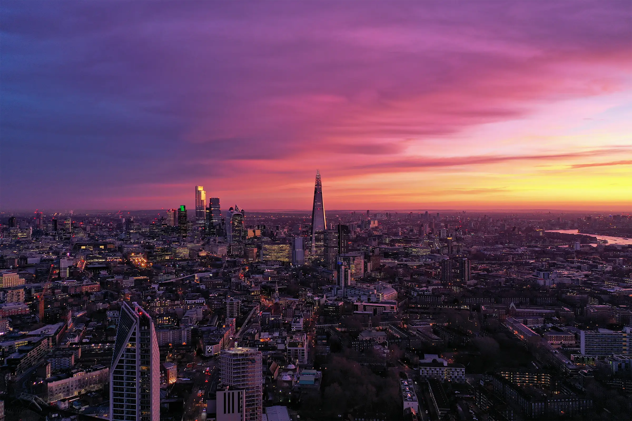 A bird's eye photograph of London, looking towards East London during sunrise.